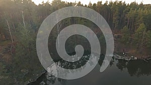 Forest landskape with a lake. People near water waching a beautiful view. Shooting from the drone.