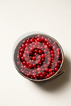 Forest lingonberries in a metal plate on a white background