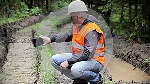 Forest officer filmed with tablet PC rutted forest road