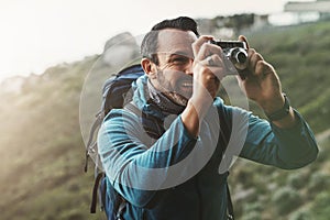Forest, photography and happy man with camera in nature for travel, hiking or journey memory. Jungle, backpack and