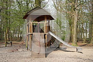 Forest playground with wooden hut and slide