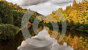 Forest river and autumn trees on sunset