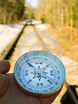 forest road with snow and hand with compass