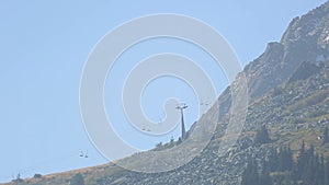 Forest and rocky mountain top with line cable cars, skiing resort in summer