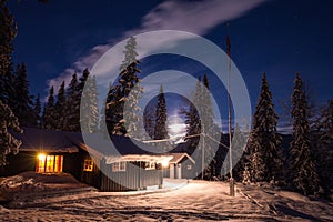 Forest scandinavian cabin in snowy woodland. Winter in Norway