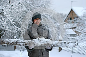 Forest worker with big hewed log