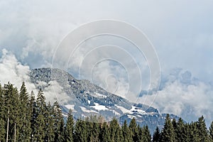 Forested mountains in dense clouds in a winter. Ziller Valle in, Austria