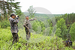 The forester looks through binoculars