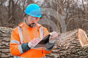 Forestry technician collecting data notes in forest