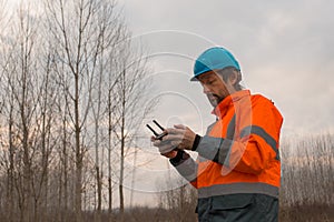 Forestry technician flying a drone with remote controller
