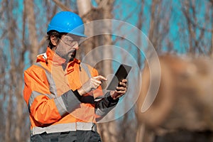 Forestry technician using digital tablet computer in forest