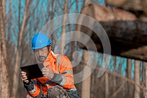 Forestry technician using digital tablet computer in forest