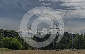 Forests and blue sky wih clouds and windy power plants and electric poles