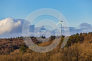 Forests in front of a wind turbine for sustainable power generation in Hohenlohekreis, Germany