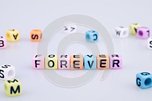 Forever word text written on colorful cube with bokeh cube word