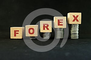 Forex or foreign exchange trading market growth, profitability and investment concept. Increasing stack of coins in wooden blocks.