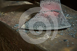 Creating iron tools in blacksmith`s on the old plank wood table