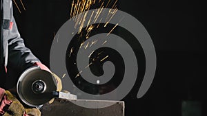 Forge workshop. Smithy manual production. Close up details of sparks, industrial worker using angle grinder and cutting