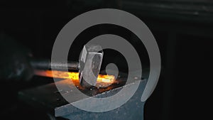 Forge workshop. Smithy manual production. Hands of smith with hammer hit on glowing hot metal, on the anvil, the forging