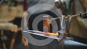 Forge workshop. Smithy manual production. Hands of smith with hammer hit on glowing hot metal, on the anvil, the forging