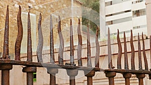 Forged curved sharp spikes of ancient iron fence with rust