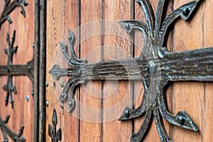 Forged door pattern, decorative. Old vintage entrance, massive heavy wooden door of church or cathedral