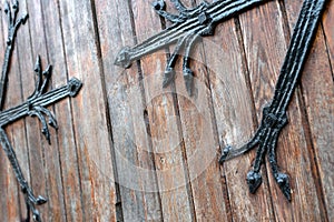 Forged door pattern, decorative. Old vintage entrance, massive heavy wooden door of church or cathedral