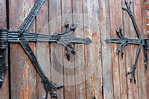 Forged door pattern, decorative. Old vintage entrance, massive heavy wooden door of church or cathedral