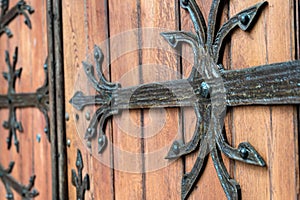 Forged door pattern, decorative. Old vintage entrance, massive heavy wooden door of church or cathedral