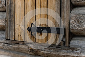 Forged hinge on the wooden shutter close up. ancient Russian architecture