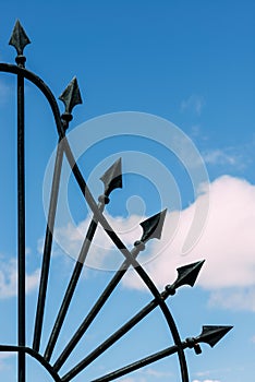 Forged iron fence with arrows on blue sky background in Lisbon, Portugal