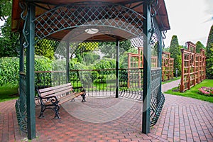 Forged iron gazebo with ceiling lamp with white diffuser, place for relaxing.