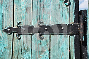 Forged metal hinges of an old wooden door.