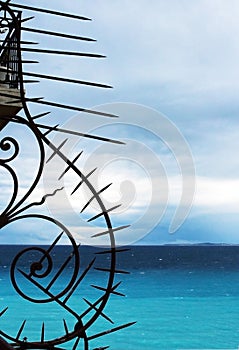 Forged spiral metal stylish architectural design detail element on blue sky and sea water background