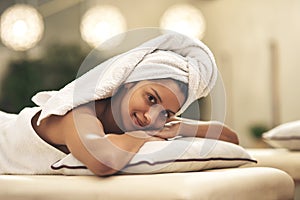Forget about everything, and just dedicate yourself to relax. a young woman smiling while lying on a massage bed at a