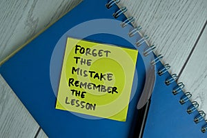 Forget The Mistake Remember The Lesson write on sticky notes isolated on office desk