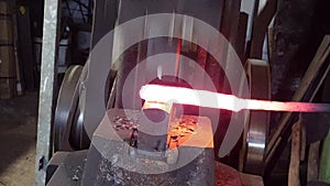 forging red hot metal with a spring hammer