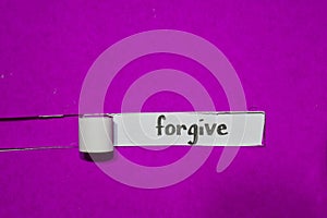 Forgive, Inspiration, Motivation and business concept on purple torn paper photo
