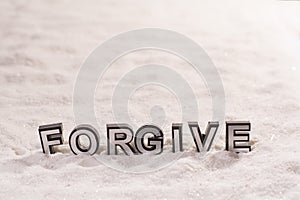 Forgive word on white sand photo