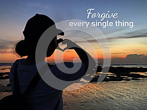 Forgiveness inspirational quote - Forgive every single thing. With young woman silhouette making heart love sign at sunset.