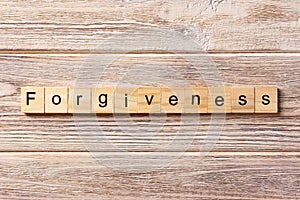 Forgiveness word written on wood block. forgiveness text on table, concept