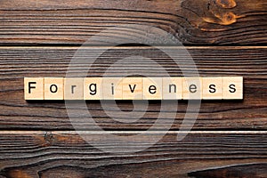 Forgiveness word written on wood block. forgiveness text on table, concept