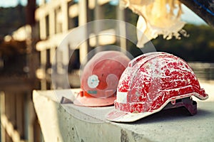 Forgotten builder helmet lying on a concrete block on the blurry background Bridge construction at day light