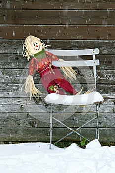 Forgotten doll on the old chair in winter