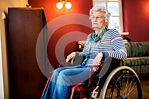 Forgotten by the family, sad senior woman at wheelchair