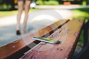 Forgotten mobile phone on bench in park