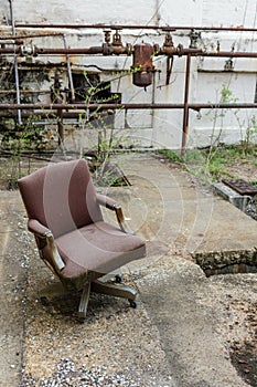 Forgotten office chair left discarded outside an abandoned factory