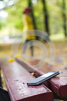 Forgotten smartphone on a park bench