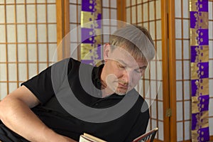 A foriegn man studing Japanese from a book