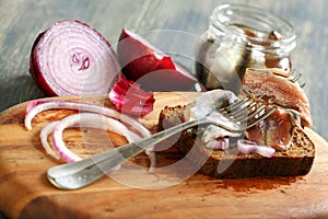 Fork with anchovies, rye bread and red onion.